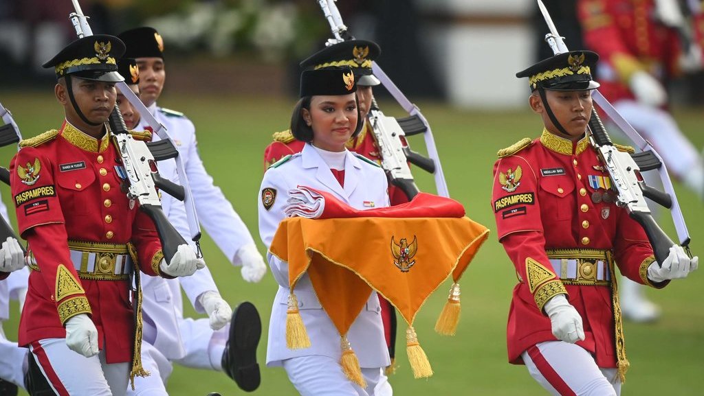 Anggota Paskibraka 2024 asal Bali Ni Komang Tri Setia (tengah) bersama anggota Paskibraka lainnya membawa duplikat Bendera Pusaka pada upacara penurunan bendera dalam rangka HUT ke-79 Kemerdekaan Republik Indonesia di lapangan upacara Istana Negara Ibu Kota Nusantara (IKN), Penajam Paser Utara, Kalimantan Timur, Sabtu (17/8/2024). ANTARA FOTO/Hafidz Mubarak A/app/rwa. Upacara penurunan duplikat Bendera Pusaka di IKN