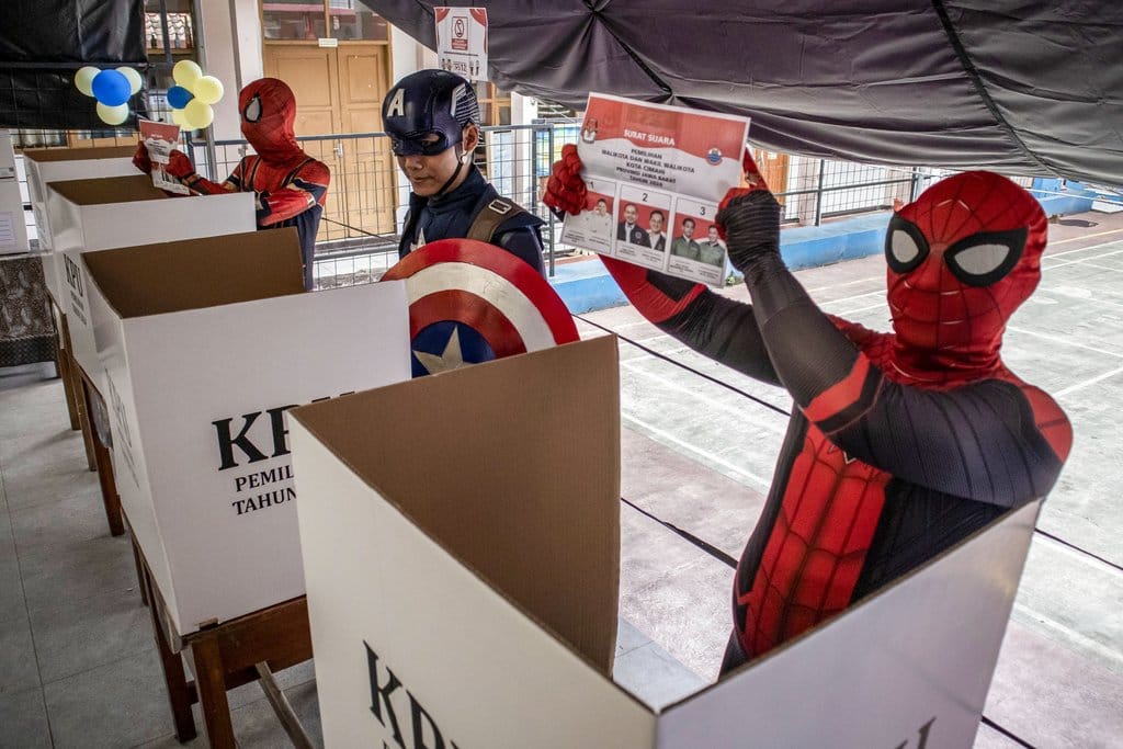 Petugas berkostum Superhero menunjukkan surat suara sebelum menggunakan hak suaranya saat Pilkada 2024 di TPS 12 Pasir Kaliki, Kota Cimahi, Jawa Barat, Rabu (27/11/2024). Warga setempat bersama petugas KPPS berinisiatif membuat TPS Superhero untuk memeriahkan sekaligus menghibur warga dan meningkatkan partisipasi pemilih pada Pilkada 2024 di Kota Cimahi yang memiliki daftar pemilih tetap sebanyak 419.974 pemilih dengan rincian sebanyak 207.226 pemilih laki-laki dan sebanyak 212.748 pemilih perempuan. ANTARA FOTO/Abdan Syakura/agr/YU Pemungutan suara di TPS Superhero Kota Cimahi