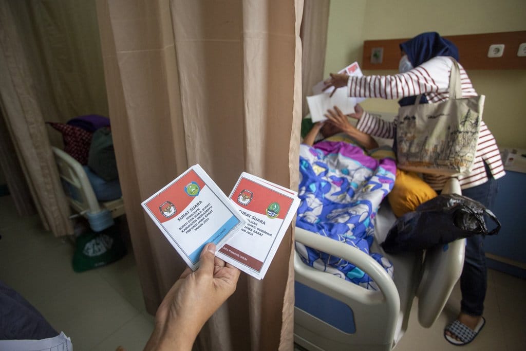 Pasien melihat surat suara sebelum melakukan pencoblosan Pilkada 2024 di RSUD Indramayu, Jawa Barat, Rabu (27/11/2024). KPU Indramayu melakukan layanan datang langsung bagi pasien yang berada di rumah sakit agar bisa menggunakan hak pilihnya pada Pilkada 2024. ANTARA FOTO/Dedhez Anggara/aww. Pemungutan suara PIlkada 2024 di rumah sakit