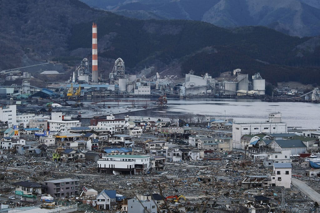 Pemandangan puing-puing dan lumpur yang tertutup tsunami menghantam Kawasan Industri hancur di Ofunato pada tanggal 23 Maret 2011, Jepang. Pada tanggal 11 Maret 2011, gempa bumi melanda Jepang dengan magnitudo 9,0, yang terbesar dalam sejarah negara yang tercatat dan salah satu dari lima yang paling kuat yang tercatat di seluruh dunia. Dalam waktu satu jam setelah gempa bumi, kota-kota yang berjajar di pantai diratakan oleh tsunami besar, yang disebabkan oleh energi yang dilepaskan oleh gempa bumi. Dengan gelombang setinggi empat atau lima meter, mereka menabrak rumah, kota, dan ladang warga sipil. Ilustrasi Gempa Tsunami Jepang