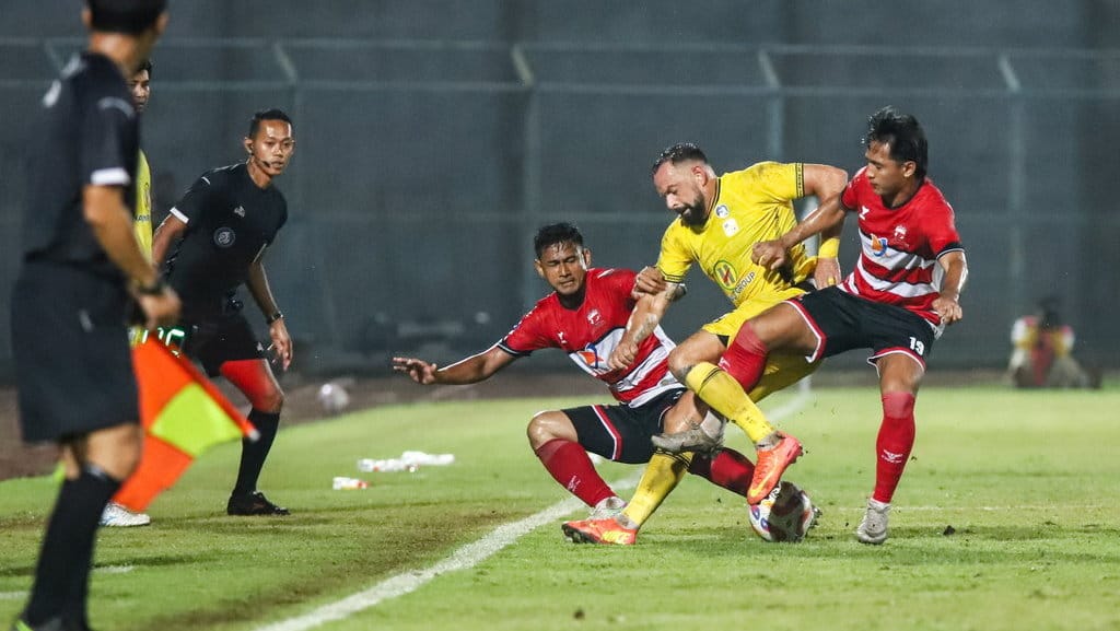 Pesepak bola Madura United Hanis Sagara Putra (kanan) dan Haudi Abdillah (ketiga kanan) berebut bola dengan pesepak bola Barito Putera Henry Matias Mier (kedua kanan) pada pertandingan BRI Liga 1 di Stadion Gelora Bangkalan, Bangkalan, Jawa Timur, Sabtu (18/1/2025). Barito Putera mengalahkan tuan rumah Madura United dengan skor 4-2. ANTARA FOTO/Rizal Hanafi/rwa. Barito Putera kalahkan Madura United