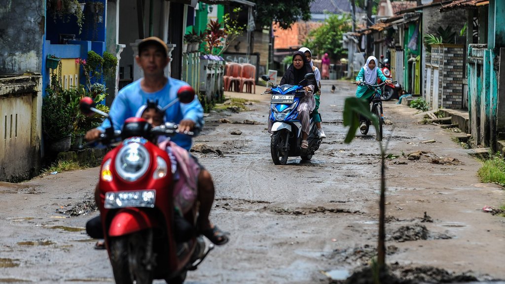 Pengendara roda dua melintas di samping pohon yang ditanam di jalan rusak di Walantaka, Kota Serang, Banten, Senin (17/3/2025). Aksi penanaman pohon pisang tersebut sebagai bentuk protes jalan rusak yang terjadi di sejumlah titik di daerah tersebut dan tak kunjung diperbaiki. ANTARA FOTO/Muhammad Bagus Khoirunas/foc. Aksi protes jalan rusak di Kota Serang