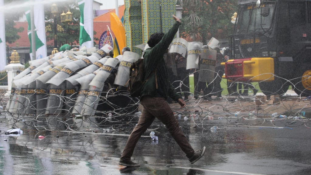 Polisi menyemprotkan air dari water canon untuk menghalau sejumlah pengunjuk rasa yang beraksi untuk menyikapi UU TNI di Surabaya, Jawa Timur, Senin (24/3/2025). ANTARA FOTO/Didik Suhartono/nz Unjuk rasa menyikapi UU TNI di Surabaya