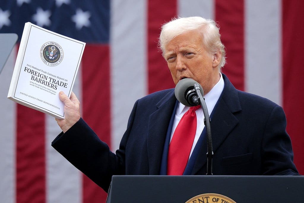Presiden AS Donald Trump mengangkat salinan Laporan Estimasi Perdagangan Nasional 2025 saat ia berpidato dalam acara pengumuman perdagangan “Make America Wealthy Again” di Rose Garden, Gedung Putih pada 2 April 2025 di Washington, DC. Trump yang menyebut acara tersebut sebagai “Hari Pembebasan” diperkirakan akan mengumumkan tarif tambahan yang menargetkan barang-barang yang diimpor ke AS. Chip Somodevilla/Getty Images/AFP (Foto oleh CHIP SOMODEVILLA / GETTY IMAGES NORTH AMERICA / Getty Images via AFP) Donald Trump