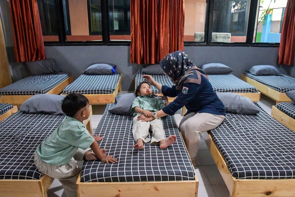 Dua petugas mengajarkan anak yang diasuh untuk menggambar di Taman Anak Sejahtera Arutala (TAS), Kebon Bawang, Jakarta Utara, Senin (5/5/2025). ANTARA FOTO/Sulthony Hasanuddin/bar Tempat penitipan anak gratis di Jakarta