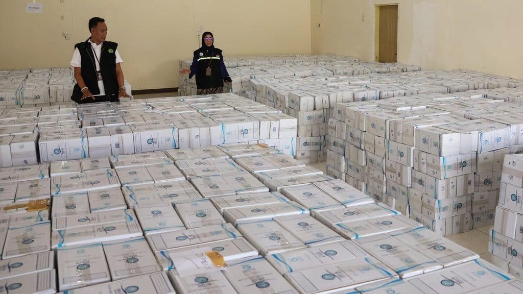 Petugas mengecek tumpukan kotak berisi satu botol air zamzam setibanya di Asrama Haji Makassar, Sulawesi Selatan, Jumat (23/5/2025). ANTARA FOTO/Arnas Padda/nym. Air zamzam untuk jamaah haji tiba di Makassar