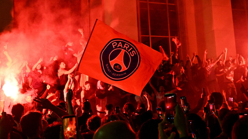 Para pendukung Paris Saint-Germain (PSG) menyalakan suar saat berkumpul di Place Trocadero di depan Menara Eiffel di Paris pada 31 Mei 2025, selama perayaan setelah kemenangan 5-0 mereka dalam pertandingan final Liga Champions UEFA antara Paris Saint-Germain (PSG) dan Inter Milan yang diadakan di Munich. (Photo by Hugo MATHY / AFP) Perayaan Kemenangan PSG di Paris
