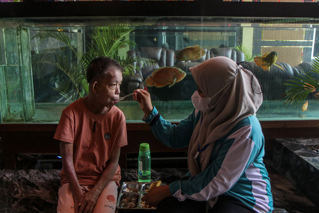 Perawat magang menyuapkan makanan kepada seorang lansia yang dirawat di Panti Jompo Yayasan Netizen Cinta Singkawang, Kota Singkawang, Kalimantan Barat. ANTARA/Jessica Wuysang Menjaga asa di hotel lansia