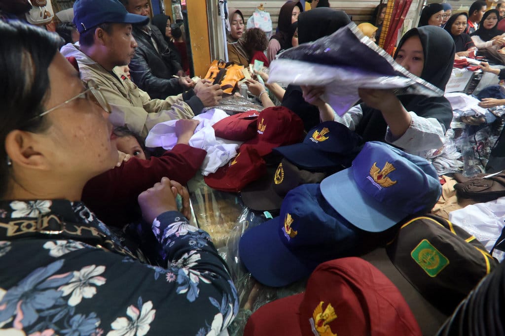 Penjual seragam sekolah melayani calon pembeli di salah satu lapak seragam sekolah di Cibinong, Kabupaten Bogor, Jawa Barat, Jumat (11/7/2025). ANTARA FOTO/Yulius Satria Wijaya/sgd Penjualan seragam sekolah jelang tahun ajaran baru