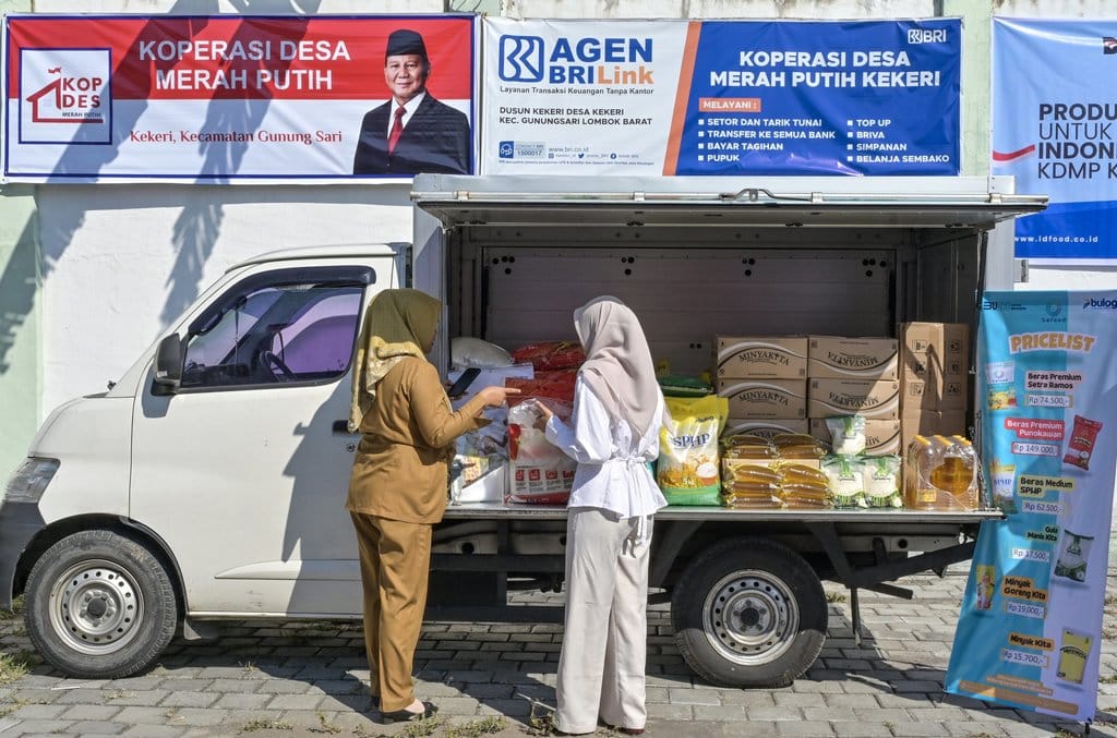 Pedagang melayani konsumen membeli beras di salah satu gerai keliling yang menjual Sembako saat peluncuran Koperasi Merah Putih Desa Kekeri, di Desa Kekeri, Kecamatan Gunungsari, Lombok Barat, NTB, Senin (21/7/2025). ANTARA FOTO/Ahmad Subaidi/YU Koperasi Desa Merah Putih di NTB