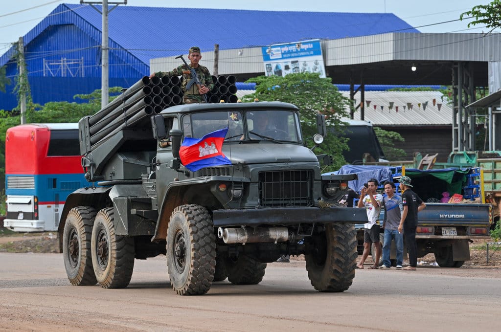 Seorang tentara Kamboja berdiri di atas truk yang membawa peluncur roket BM-21 buatan Rusia yang melaju di sepanjang jalan di Provinsi Oddar Meanchey pada 25 Juli 2025. Thailand dan Kamboja terlibat dalam bentrokan militer paling berdarah dalam lebih dari satu dekade pada 24 Juli, menewaskan sedikitnya 12 orang saat kedua belah pihak bertempur dengan tank, artileri, dan pasukan darat di zona perbatasan yang disengketakan. (Foto oleh TANG CHHIN Sothy / AFP) Tentara Kamboja