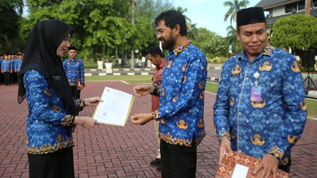 Gubernur Aceh, Muzakir Manaf (tengah) menyerahkan secara simbolis surat keputusan pengangkatan kepada seorang perwakilan Pegawai Pemerintah Dengan Perjanjian Kerja (PPPK) di Kantor Gubernur Aceh, Banda Aceh, Senin (4/8/2025). ANTARA FOTO/Ampelsa/YU Penyerahan SK PPPK provinsi Aceh