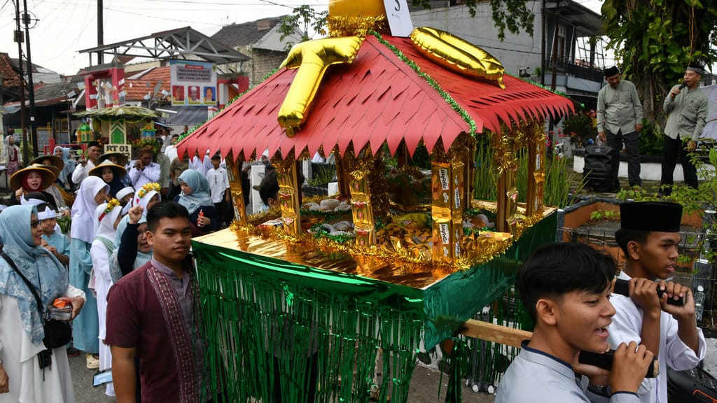 Peserta memikul dongdang (wadah atau miniatur bangunan tempat hasil bumi dan makanan) pada Festival Dongdang Maulid di Perumahan Villa Ciomas Indah, Kabupaten Bogor, Jawa Barat, Minggu (7/9/2025). ANTARA FOTO/Arif Firmansyah/tom. Festival Dongdang Maulid di Bogor