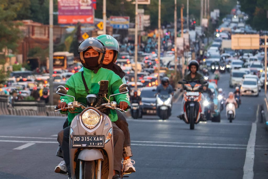 Pengemudi ojek online (ojol) mengangkut penumpang di Makassar, Sulawesi Selatan, Selasa (16/9/2025). ANTARA FOTO/Arnas Padda/foc. Diskon iuran BPJS Ketenagakerjaan untuk ojol