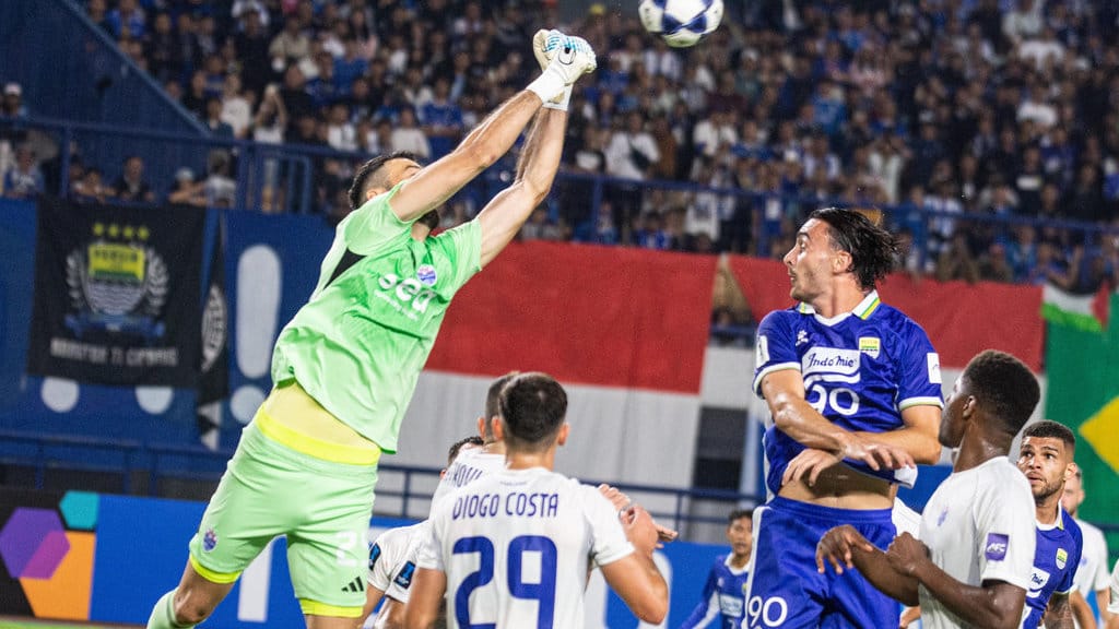 Penjaga gawang Lion City Sailors Ivan Susak (kiri) berebut bola udara dengan pesepak bola Persib Bandung Andrew Jung (ketiga kanan) pada pertandingan Fase Grup G AFC Champions League (ACL) II di Stadion Gelora Bandung Lautan Api (GBLA), Bandung, Jawa Barat, Kamis (18/9/2025). Persib Bandung ditahan imbang oleh tamunya Lion City Sailors dari Singapura dengan skor akhir 1-1. ANTARA FOTO/Novrian Arbi/bar Persib imbang melawan Lion City Sailors