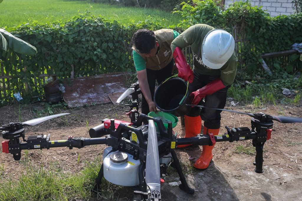 Proses menuangkan larutan pestisida ke dalam tangki drone sebelum penyemprotan di area persawahan. ANTARA FOTO/Angga Budhiyanto/foc. Proses menuangkan larutan pestisida ke dalam tangki drone sebelum penyemprotan di area persawahan