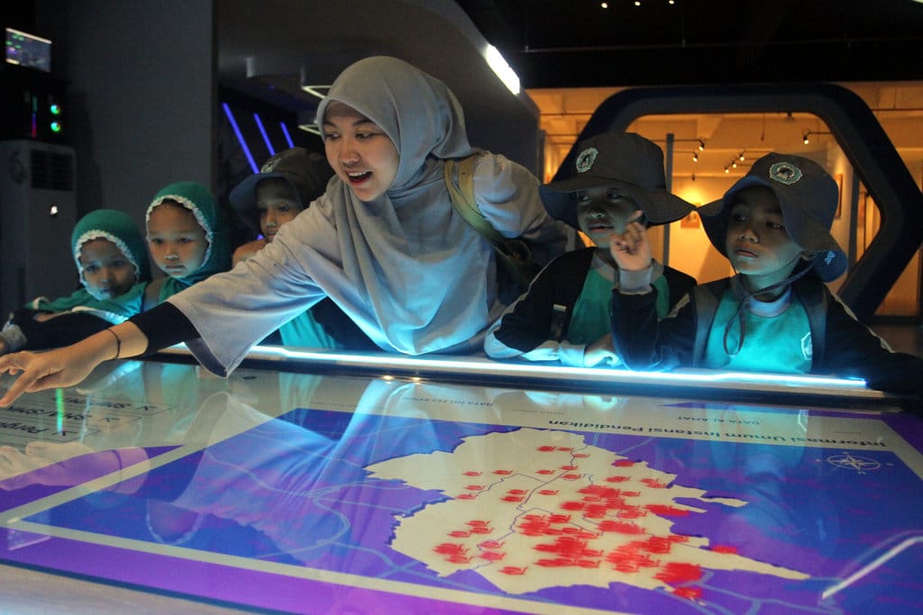 Guru dan siswa SD IT Al Rahbini melihat peta digital yang disediakan di Malang Creative City Planning Gallery, Jawa Timur, Kamis (16/10/2025). ANTARA FOTO/Ari Bowo Sucipto/nz. Ruang digital ramah anak di Malang