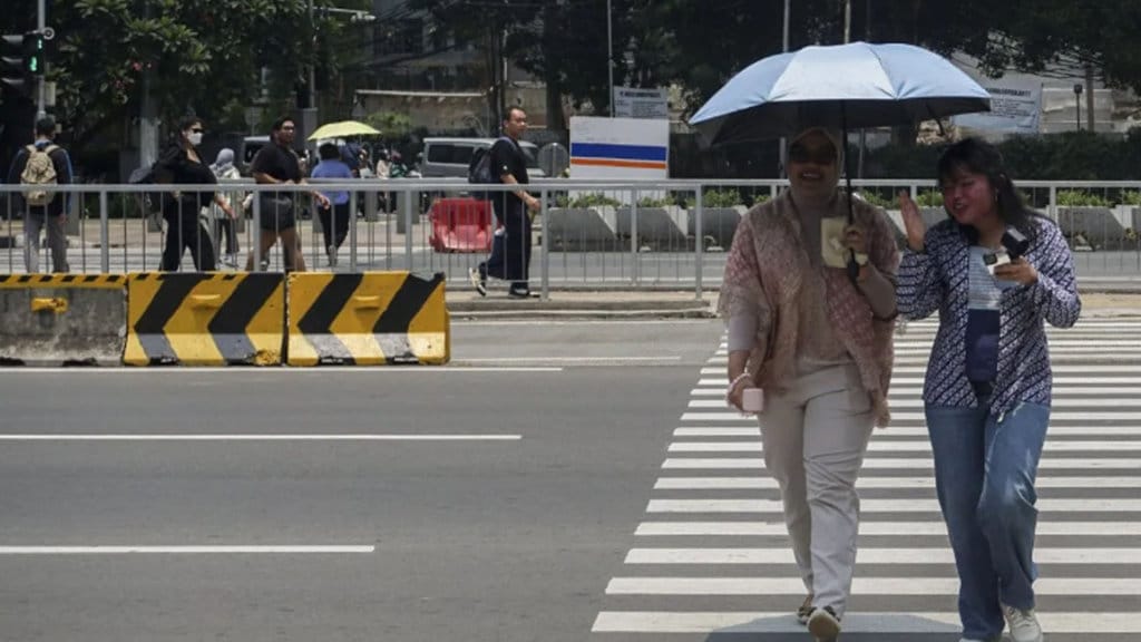Warga melintasi pelican crossing di Jakarta, Kamis (9/10/2025). Badan Meteorologi, Klimatologi, dan Geofisika (BMKG) menyatakan sebagian besar wilayah Jakarta pada 8â9 Oktober 2025 mengalami fenomena kulminasi, yaitu saat matahari berada di titik tertinggi di langit suatu wilayah sehingga bayangan akan tegak, pendek, atau menghilang karena bertumpuk dengan benda itu sendiri. ANTARA FOTO/Ika Maryani/hma/nym. (ANTARA FOTO/IKA MARYANI) Fenomena cuaca panas 2025