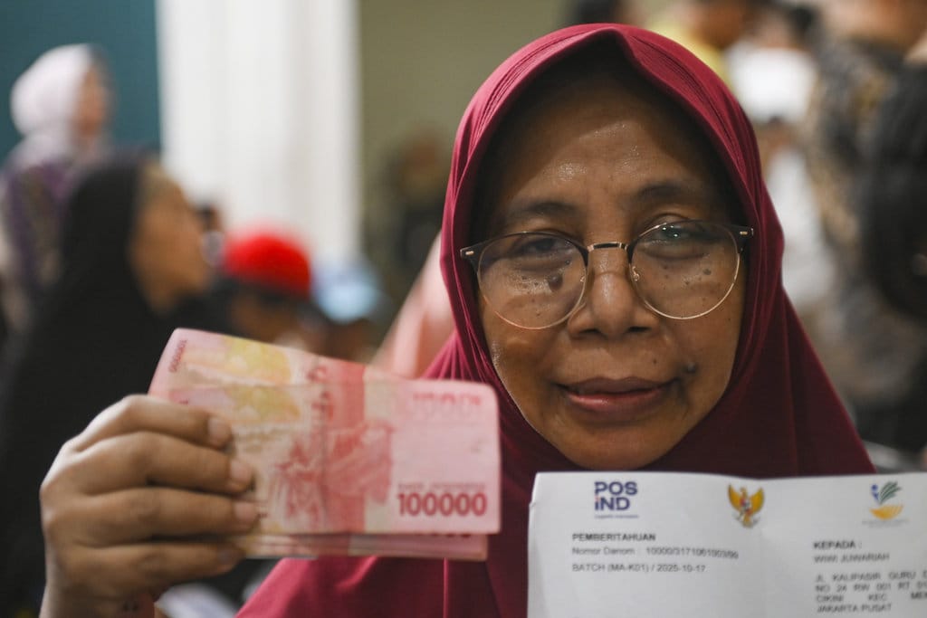Penerima BLT menunjukan uang tunai yang diterima saat pengumuman paket stimulus ekonomi di Kantor Pos Cikini, Jakarta, Jumat (17/10/2025). ANTARA FOTO/Hafidz Mubarak A/YU Pemerintah umumkan paket stimulus ekonomi tambahan