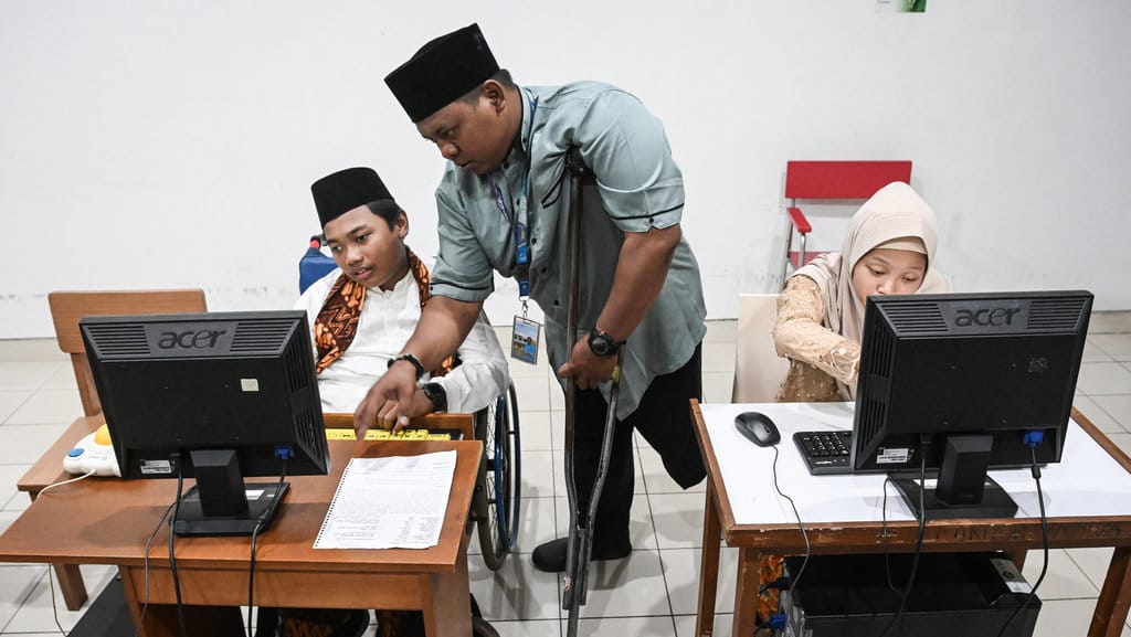 Guru penyandang disabilitas, Agung Cahyo Nugroho (tengah) mengajarkan ilmu komputer kepada siswa di SLB Yayasan Pembinaan Anak Cacat (YPAC) Jakarta, Selasa (25/11/2025). ANTARA FOTO/Sulthony Hasanuddin/bar Guru penyandang disabilitas mengajar di sekolah luar biasa