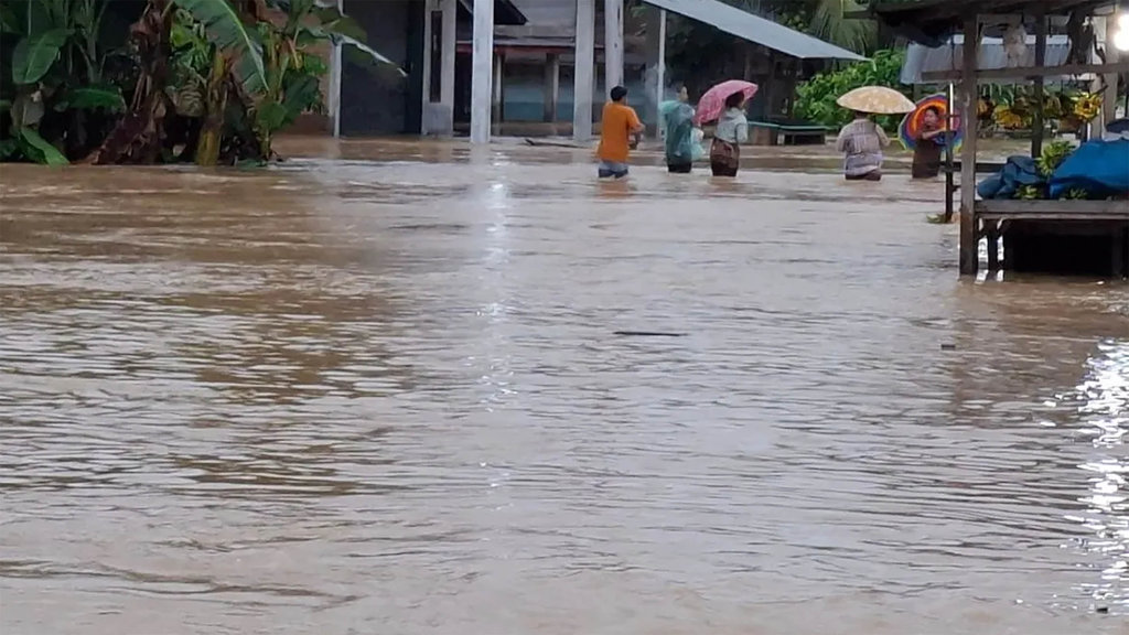 Arus lalu lintas di jalan nasional tepatnya di Nagari Aia Gadang Kecamatan Pasaman Kabupaten Pasaman Barat hingga Selasa (25/11) pagi masih terputus karena genangan air masih menutupi badan jalan akibat luapan air Sungai Batang Pasaman sejak Senin (23/11/2025) malam. ANTARA/Altas Maulana. (Arus lalu lintas terputus akibat banjir) Jalan Nasional Pasaman Barat