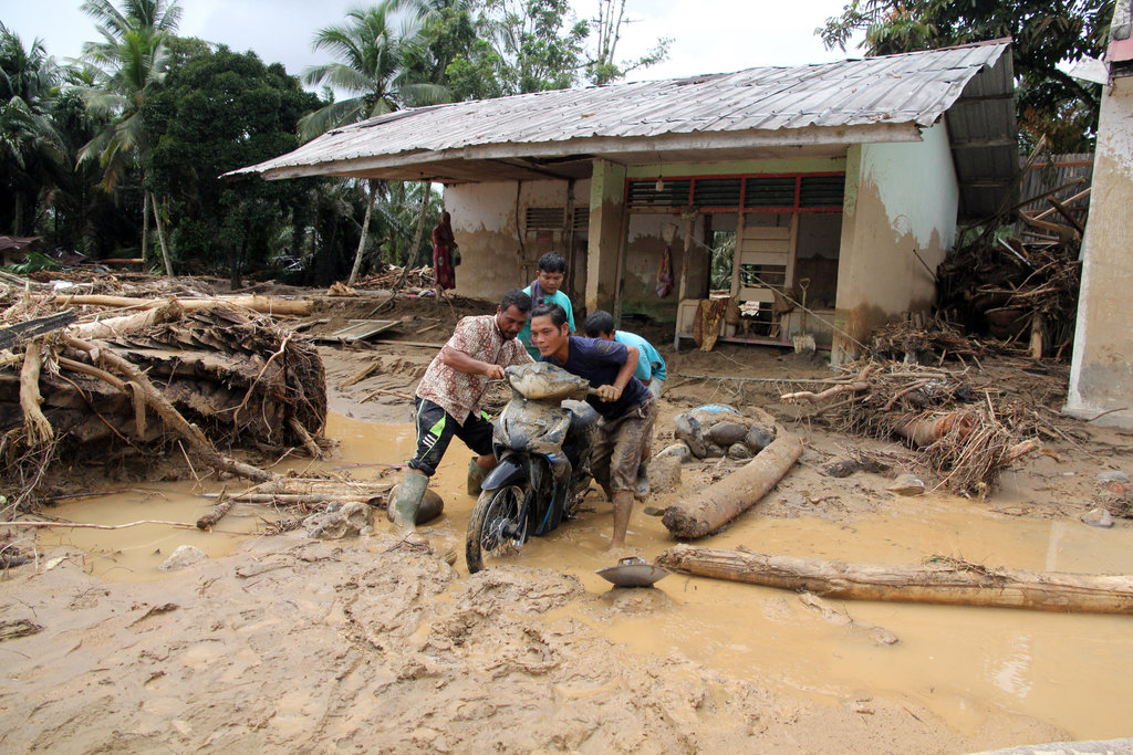 Warga mendorong sepeda motor melintas di area banjir bandang di Desa Aek Garoga, Kecamatan Batang Toru, Tapanuli Selatan, Sumatera Utara, Jumat (28/11/2025). Banjir bandang yang terjadi pada Selasa (25/11/2025) di daerah tersebut mengakibatkan 32 orang meninggal dan sejumlah rumah warga rusak, jalan berlumpur, kendaraan rusak dan berdampak kepada 250 kepala keluarga. ANTARA FOTO/Yudi Manar/YU Dampak banjir bandang di Tapanuli Selatan