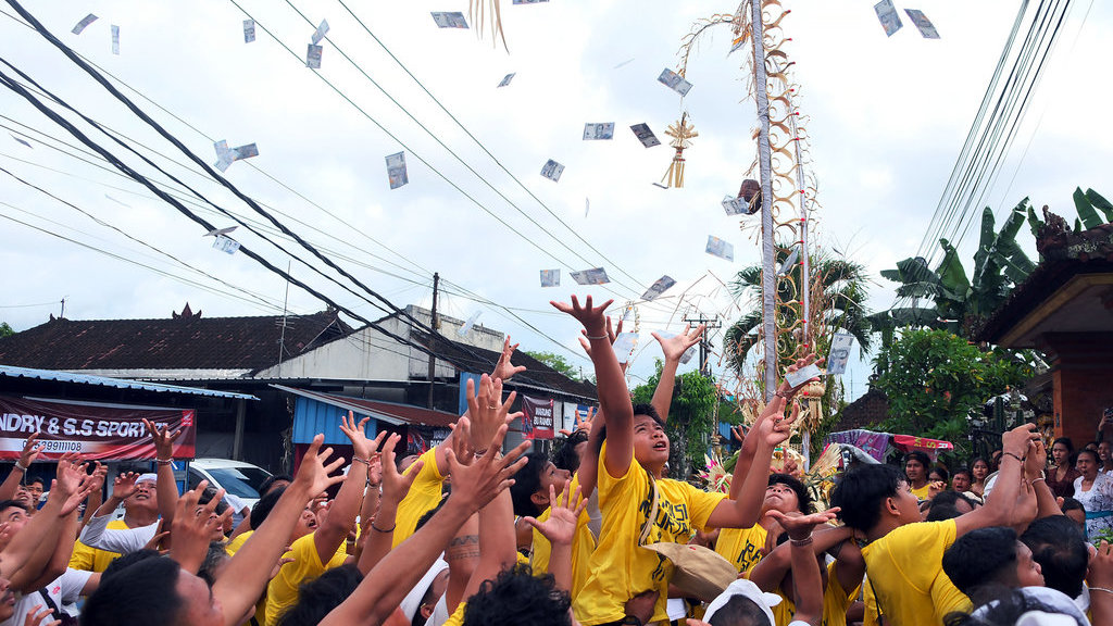 Warga berebut uang yang dilemparkan oleh warga lainnya saat tradisi Mesuryak pada perayaan Hari Raya Kuningan di Desa Bongan Gede, Tabanan, Bali, Sabtu (29/11/2025). ANTARA FOTO/Nyoman Hendra Wibowo/tom. Tradisi Mesuryak Hari Raya Kuningan