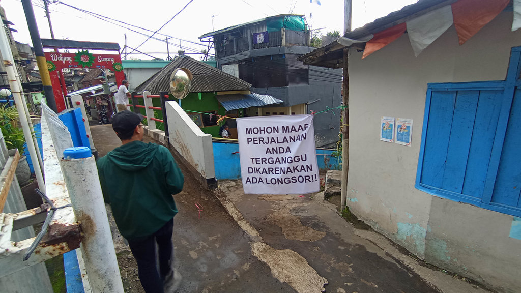 Akses jalan warga terganggu akibat luapan air Sungai Cipaganti yang sebabkan longsor serta kirmir jebol di Gang Swadaya 3, Jalan Cihampelas, Kecamatan Coblong, Kota Bandung, Senin (1/12/2025). Amad NZ/tirto.id Tanah Longsor Gang Swadaya 3