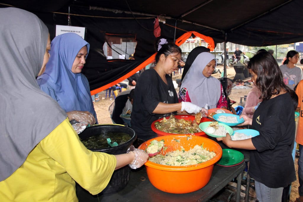 Petugas membagikan makanan kepada warga yang terdampak banjir bandang di Desa Aek Garoga, Kecamatan Batang Toru, Tapanuli Selatan, Sumatera Utara, Senin (1/12/2025). ANTARA FOTO/Yudi Manar/YU Dapur umum korban banjir bandang di Tapanuli Selatan