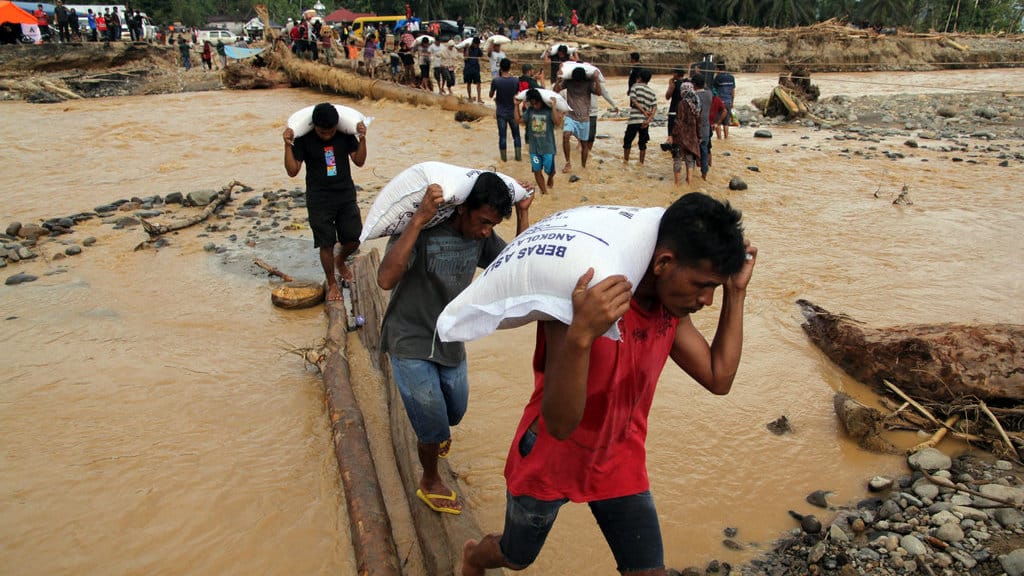 Petugas memikul beras untuk dibagikan kepada korban banjir bandang di Desa Aek Garoga, Kecamatan Batang Toru, Tapanuli Selatan, Sumatera Utara, Senin (1/12/2025). ANTARA FOTO/Yudi Manar/YU Penyaluran bantuan korban banjir bandang
