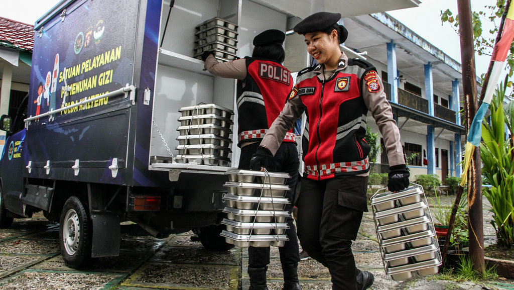 Anggota polisi membawa paket Makan Begizi Gratis (MBG) yang disalurkan oleh Satuan Pelayanan Pemenuhan Gizi (SPPG) Polda Kalimantan Tengah di MA An-Nur Palangka Raya, Kalteng, Kamis (4/12/2025). ANTARA FOTO/Auliya Rahman/nz Satuan Pelayanan Pemenuhan Gizi Polda Kalteng