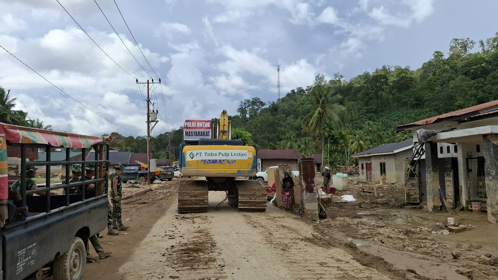 Ekskavator bertuliskan PT Toba Pulp Lestari di Desa Garoga, Kecamatan Batang Toru, Kabupaten Tapanuli Selatan, Sumatra Utara, Sabtu (6/11/2025). tirto.id/M. Irfan Al Amin Bantuan Alat Berat di Tapsel