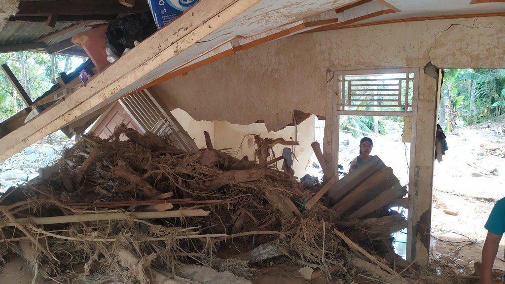 Kondisi rumah Ramanis (56) yang hancur saat banjir bandang melanda Kampung Guo, Kelurahan Kuranji, Kecamatan Kuranji, Kota Padang, Sumatera Barat, Senin (8/12/2025). Rumah impian Ramanis selama puluhan tahun itu hancur setelah diterjang derasnya air dan dihantam batu serta kayu. (tirto.id/Fajar Alfaridho Herman) Rumah Ramanis Diterjang Banjir Bandang di Padang