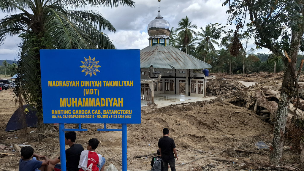 Tumpukan gelondongan kayu mengitari salah satu masjid di Desa Garoga, Kecamatan Batang Toru, Kabupaten Tapanuli Selatan, Sumatra Utara pada Sabtu (6/12/2025). tirto.id/M. Irfan Al Amin Tumpukan gelondongan kayu di Tapanuli Selatan