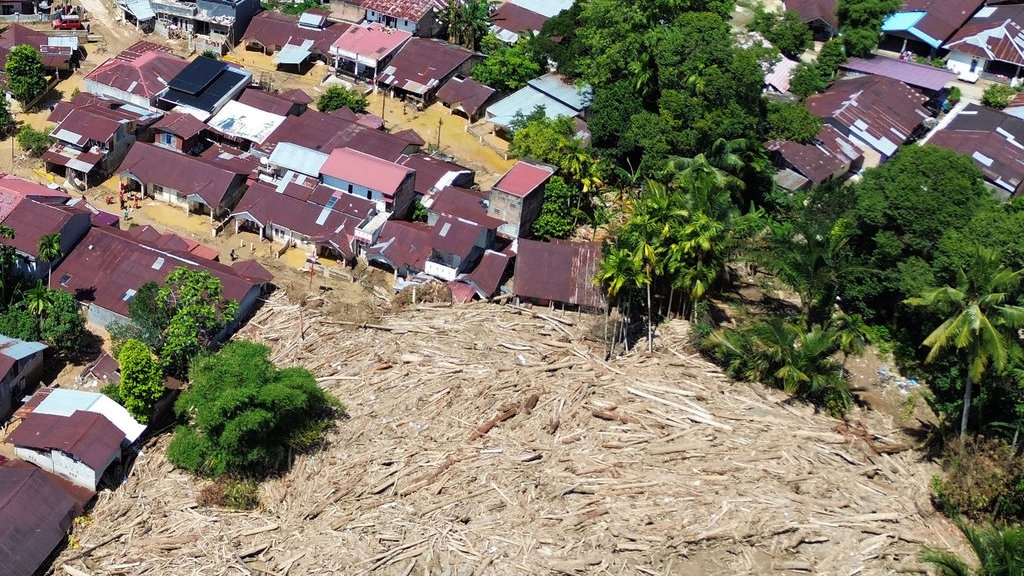 Foto udara tumpukan gelondongan kayu di permukiman di Tabiang Bandang Gadang, Nanggalo, Padang, Sumatera Barat, Selasa (9/12/2025). ANTARA FOTO/Iggoy el Fitra/tom. Tumpukan kayu gelondongan di permukiman