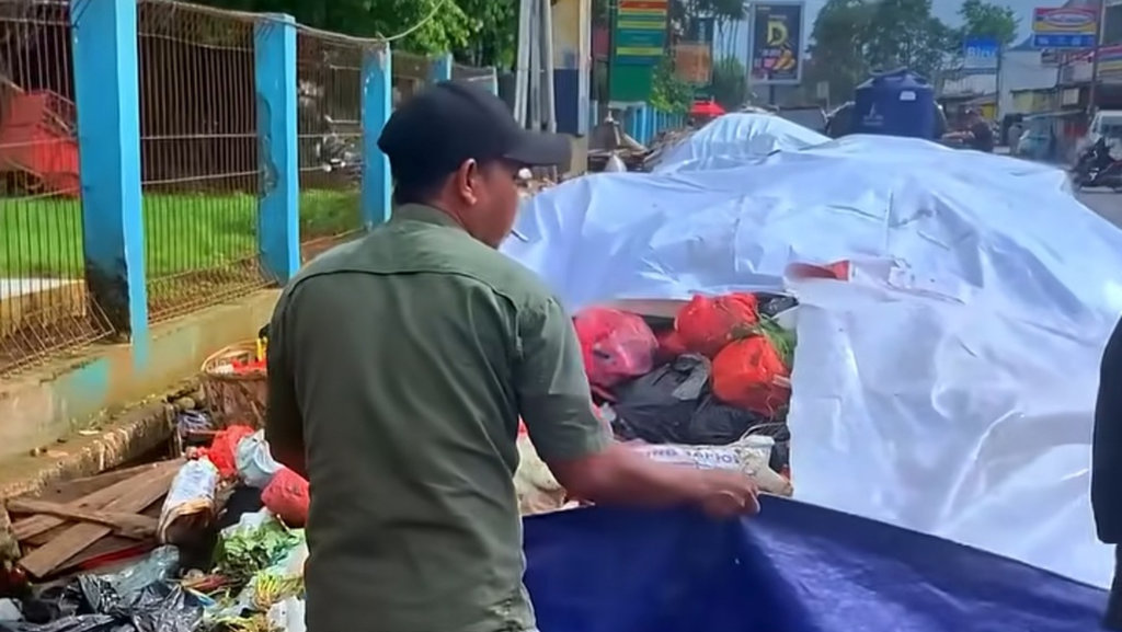 Petugas Menutup tumpukan sampah di Bawah Fly Over Ciputat dengan terpal untuk mengurangi bau dan ceceran air Lindi. (Foto: Jupri Nugroho) Tumpukan Sampah di Kota Tangsel