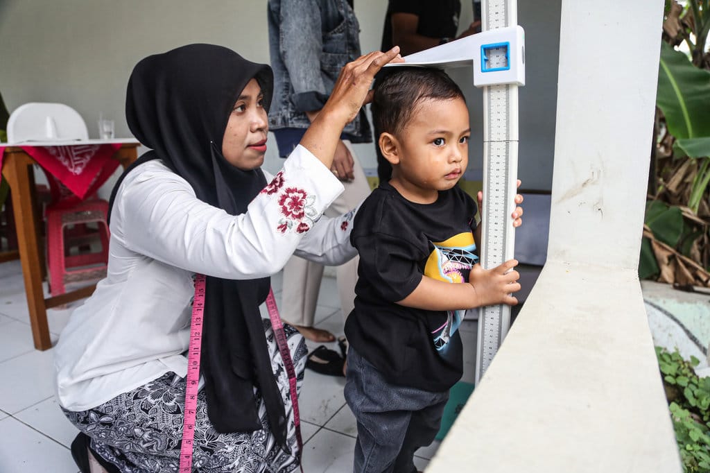 Kader posyandu mengukur tinggi badan anak balita saat layanan pemeriksaan kesehatan gratis di Posyandu Dahlia, Semarang, Jawa Tengah, Senin (15/12/2025). ANTARA FOTO/Makna Zaezar/nz Pemeriksaan kesehatan gratis bagi lansia dan balita