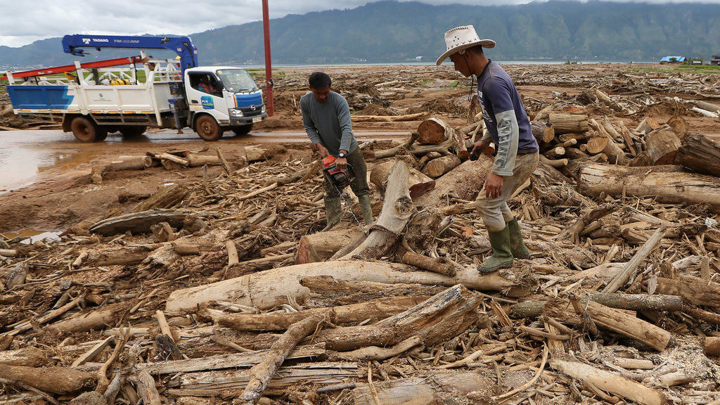 Warga memotong batang kayu yang terbawa tanah longsor saat pembersihan lahan dan pemukiman di Toweran Uken, Lut Tawar, Aceh Tengah, Aceh, Jumat (2/1/2026). ANTARA FOTO/Irwansyah Putra/YU Membersihkan tumpukan kayu longsor Aceh Tengah