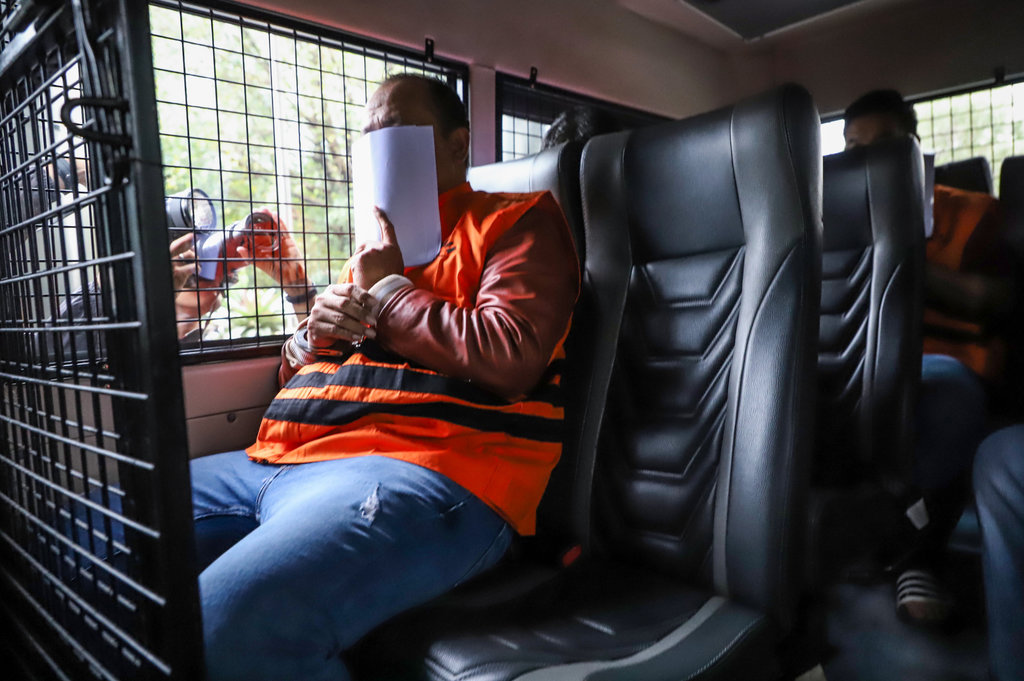 Staf PT Wanatiara Persada Edy Yulianto menggunakan rompi tahanan di dalam mobil tahanan usai menjalani pemeriksaan di Gedung Merah Putih KPK, Jakarta, Minggu (11/1/2026). ANTARA FOTO/Asprilla Dwi Adha/agr Tersangka dugaan suap pemeriksaan pajak