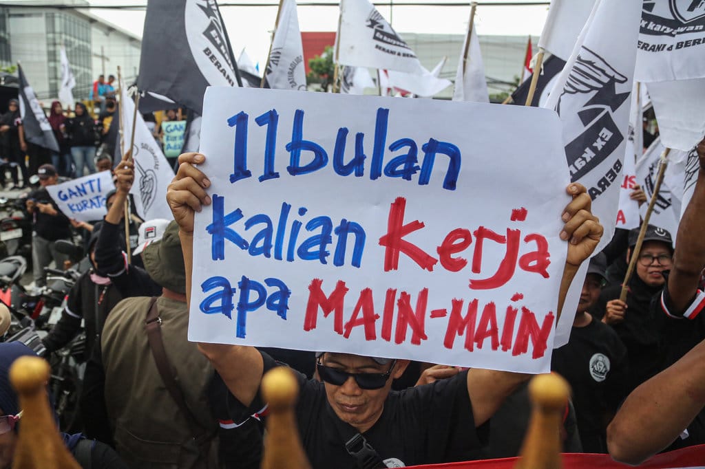 Mantan buruh dan karyawan Sritex membentangkan poster saat melakukan aksi unjuk rasa di depan kantor Pengadilan Negeri Semarang, Jawa Tengah, Senin (12/1/2026). ANTARA FOTO/Makna Zaezar/nz Unjuk rasa mantan pekerja PT Sritex di Semarang