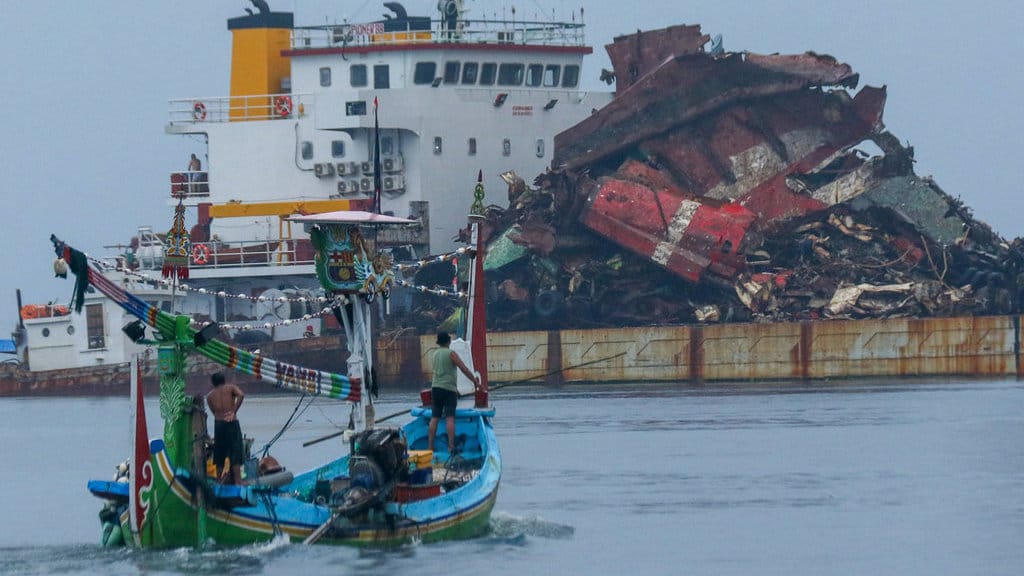 Kapal nelayan melintas di dekat bangkai KMP Tunu Pratama Jaya yang diangkat menggunakan Kapal tongkang Bercakar di Pelabuhan Marina Boom, Banyuwangi, Jawa Timur, Kamis (12/2/2026). ANTARA FOTO/Budi Candra Setya/foc. Hasil pengangkatan KMP Tunu
