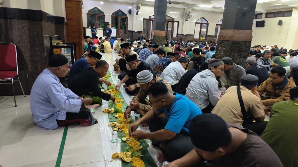 Kegiatan megibung yang dilakukan di Masjid Baitul Makmur, Desa Tegal Kertha, Kecamatan Denpasar Barat, Bali, Minggu (08/03/2026). tirto.id/Sandra Gisela Buka puasa di Masjid Baitul Makmur