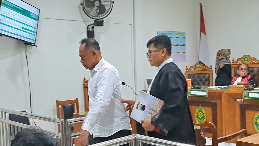 Eks Kasubdit Dalmas Ditsamapta Polda Jawa Tengah, AKBP Basuki (kemeja putih) didampingi penasihat hukumnya berjalan meninggalkan ruang sidang usai mendengar pembacaan dakwaan kasus kematian dosen Levi. Sidang berlangsung di Pengadilan Negeri Semarang, Rabu (11/3/2026). FOTO/Baihaqi Annizar Sidang Dakwaan AKBP Basuki