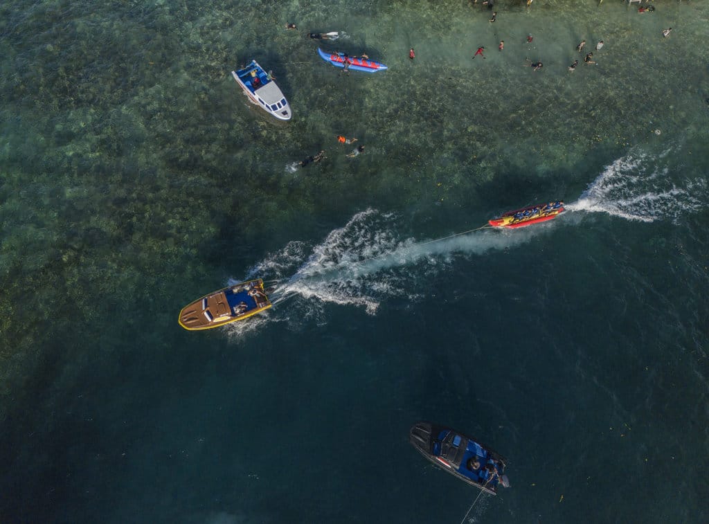 Foto udara pengunjung bermain Banana Boat di Pantai Jikomalamo Ternate, Maluku Utara, Senin (23/3/2026). Objek Wisata Pantai Jikomalamo yang menyediakan sejumlah wahana banana boat tersebut menjadi salah satu destinasi wisata favorit warga Ternate dan daerah lain dengan menargetkan jumlah kunjungan mencapai 600 wisatawan per hari terutama saat libur Lebaran 2026 yang diharapkan mampu mendongkrak pendapatan pariwisata di daerah itu. ANTARA FOTO/ Andri Saputra/foc. Liburan Lebaran di Pantai Jikomalamo Ternate