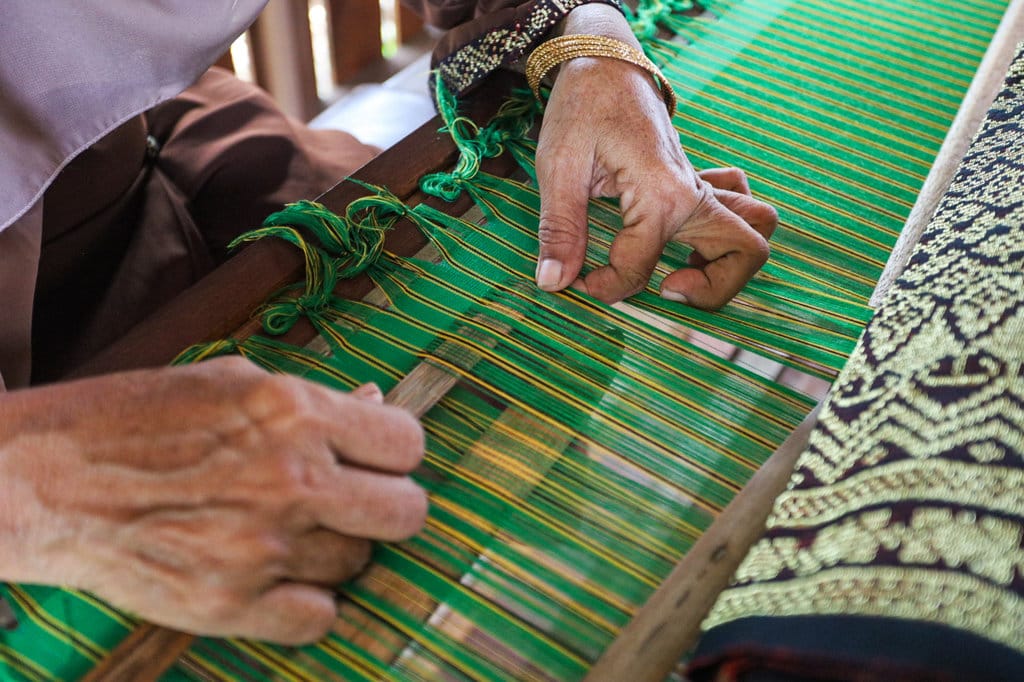 Pekerja memasukkan Sudep Bungong kedalam benang untuk membuat motif di kain tenun. Foto : tirto.di/Firhan Farabi Kain Tenun Tradisional Aceh