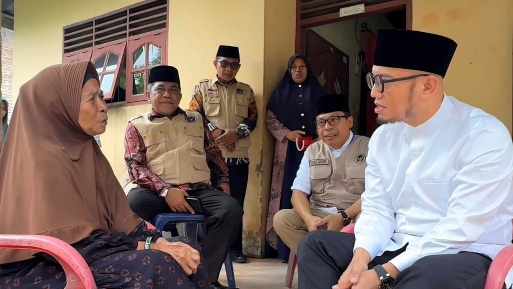 Wakil Menteri Haji dan Umrah (Wamenhaj), Dahnil Anzar Simanjuntak, sedang menyerahkan bantuan kepada Nek Sania, jemaah haji asal Serdang Begadai, Sumatra Utara. Foto: Dok. Kemenhaj. Nek Sania