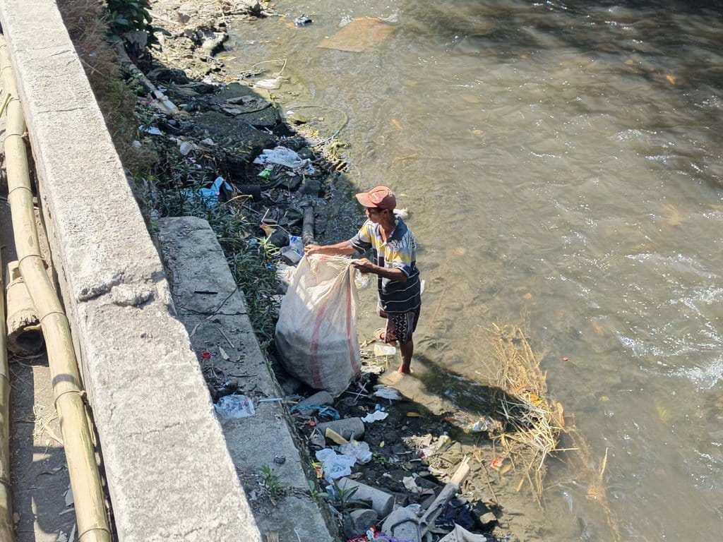 Seorang pemulung mengais sampah di aliran Sungai Premulung, Solo, Jumat (10/6/2026). tirto.id/Romensy Augustino Sungai Premulung