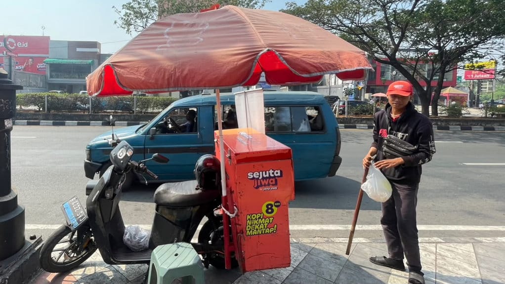 Penjual kopi keliling Sejuta Jiwa, Aaron Montolalu, sedang memangkal di Jalan Raya Margonda, Kota Depok, Jawa Barat, Kamis (23/7/2026).. FOTO/Putri Az zahra Pedagang Kopi starling vs Kopi bermerek