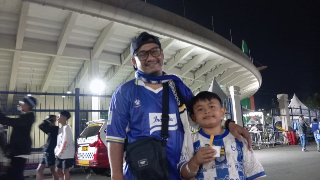 Bobotoh asal Katapang, Bayu bersama sang anak menonton pertandingan untuk pertama kalinya secara langsung di Stadion Si Jalak Harupat, Kabupaten Bandung, Sabtu (25/7/2026). Nizar/tirto.id. Newsplus Piala Presiden