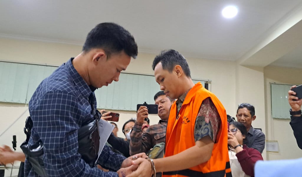 Petugas melepas borgol di tangan Bupati Cilacap nonaktif, Syamsul Auliya Rachman (baju batik), sebelum sidang pembacaan surat dakwaan kasus korupsi di Pengadilan Tipikor Semarang, Jumat (31/7/2026). FOTO/Baihaqi Annizar Sidang Dakwaan di Kasus Korupsi Bupati Cilacap